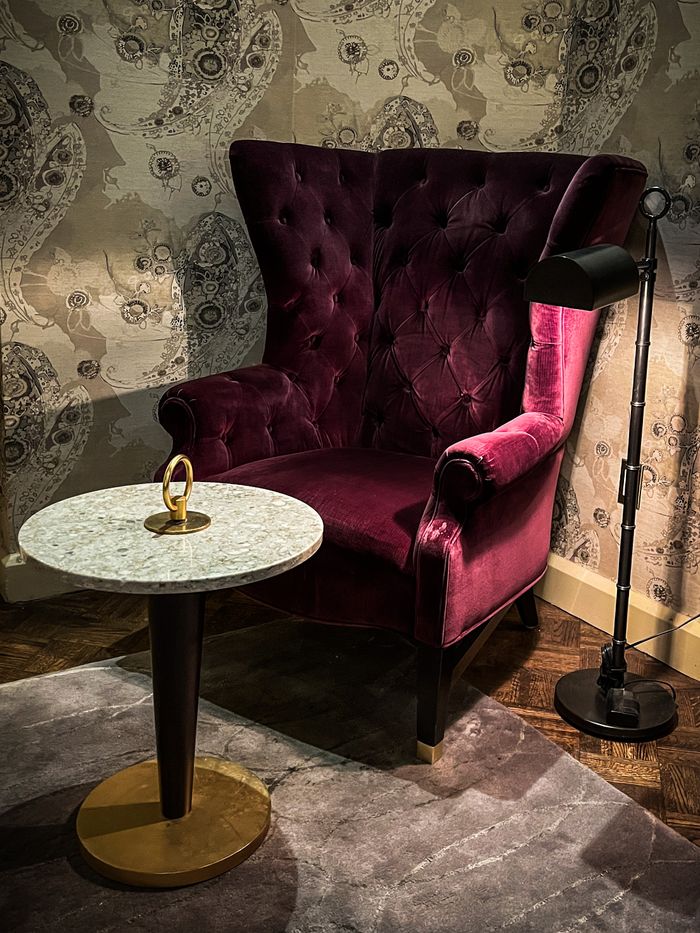 Luxurious velvet armchair with marble table in a stylish living room nook.